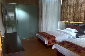 A hotel room with two beds, a wooden dresser, a wardrobe, and a patterned curtain. - Abu Ayao Inn (Yanyuan)
