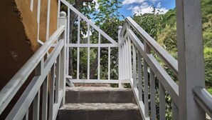 Una escalera con barandillas blancas que sube a un nivel superior.