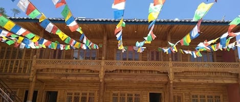 A wooden building with a balcony and colorful flags.
