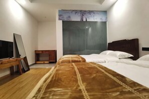 A hotel room with a bed, a TV, a wooden side table, and a painting on the wall. - Abu Ayao Inn (Yanyuan)