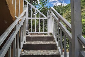 A staircase with white railings leading to a higher level. - Abu Ayao Inn (Yanyuan)