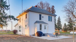 A two-story white house with a front porch, a covered outdoor seating area, and a well-maintained yard. - Barnes City House ~ 3 Mi to Hunting & Fishing! (Barnes City)