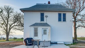 A two-story house with a front porch, a small table, and two chairs. - Barnes City House ~ 3 Mi to Hunting & Fishing! (Barnes City)