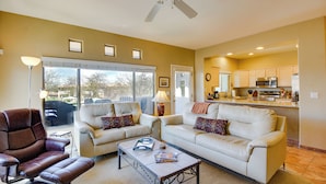 A living room with a brown leather chair, a white sofa with patterned cushions, and a coffee table. - Oro Valley Condo w/ Community Pool: Near Hiking! (Oro Valley)