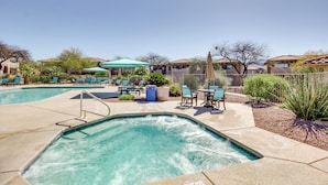 A swimming pool with lounge chairs and umbrellas, surrounded by houses. - Oro Valley Condo w/ Community Pool: Near Hiking! (Oro Valley)