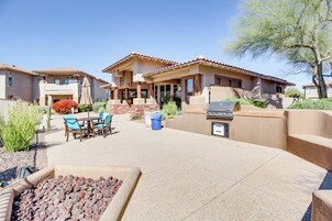 Zona residencial con patio, mobiliario exterior, una parrilla y una fogata.