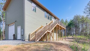 A two-story building with a wooden staircase leading to a deck.