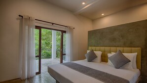 Un dormitorio con una cama grande, vista a un espacio exterior por una puerta corrediza y una pared de hormigón.