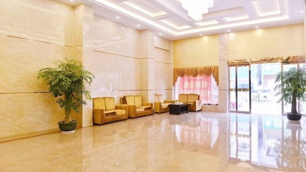 A spacious lobby with a marble floor, seating area with chairs, and potted plants. - Rongxian Wanxuan Hotel (Rong County)