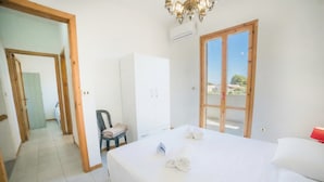 A hotel room with a bed, a wardrobe, a chair, and a view through a window. - Villetta Fresca With Garden Near The Sea (Melendugno)