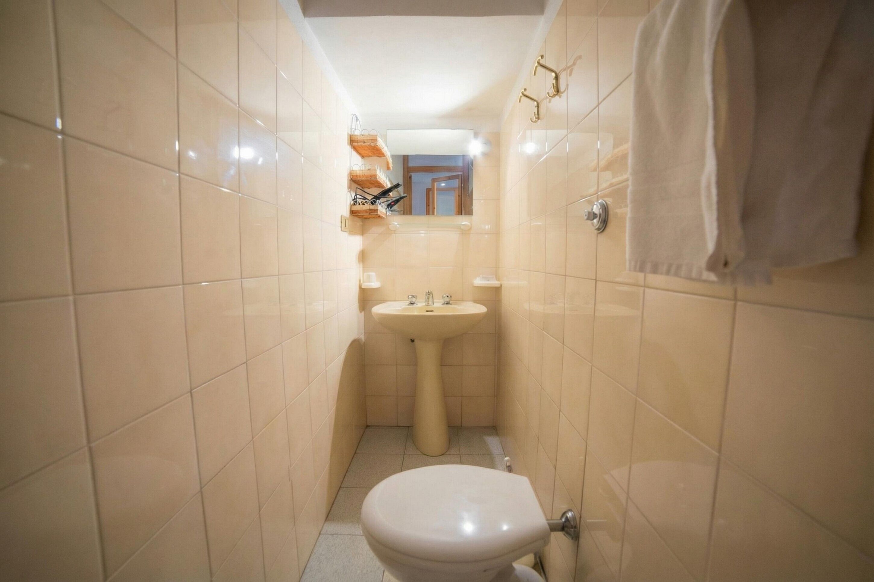 A small bathroom with a toilet, sink, and towel rack.
