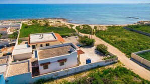 Zona residencial a la costa, amb cases, una platja i una vista despejada de l'oceà.