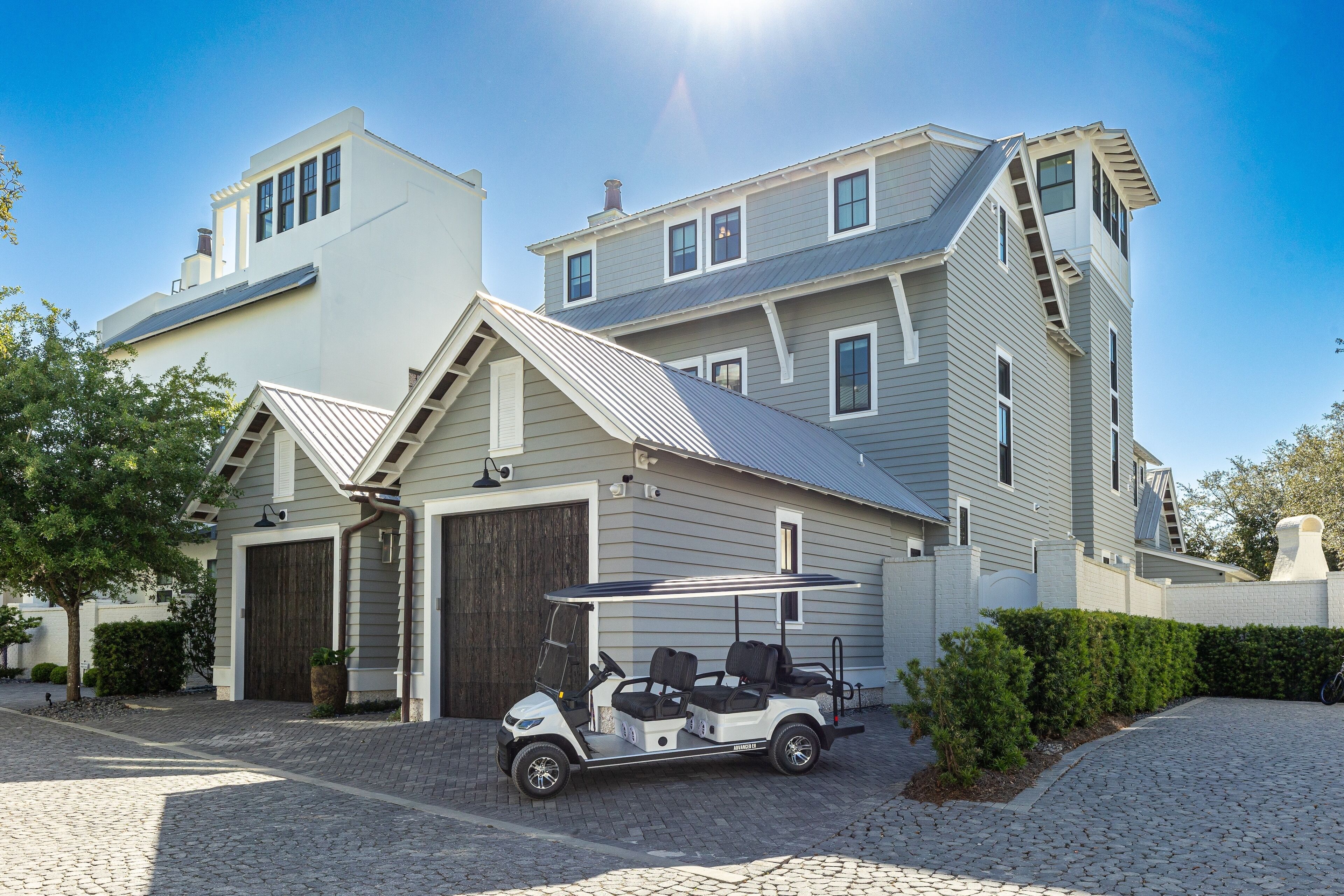 A two-story house with a garage, a covered porch, and a golf cart parked in front.