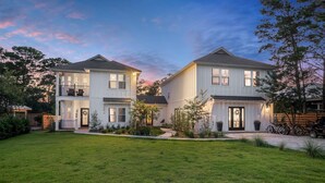 A two-story house with a well-maintained lawn and a driveway.