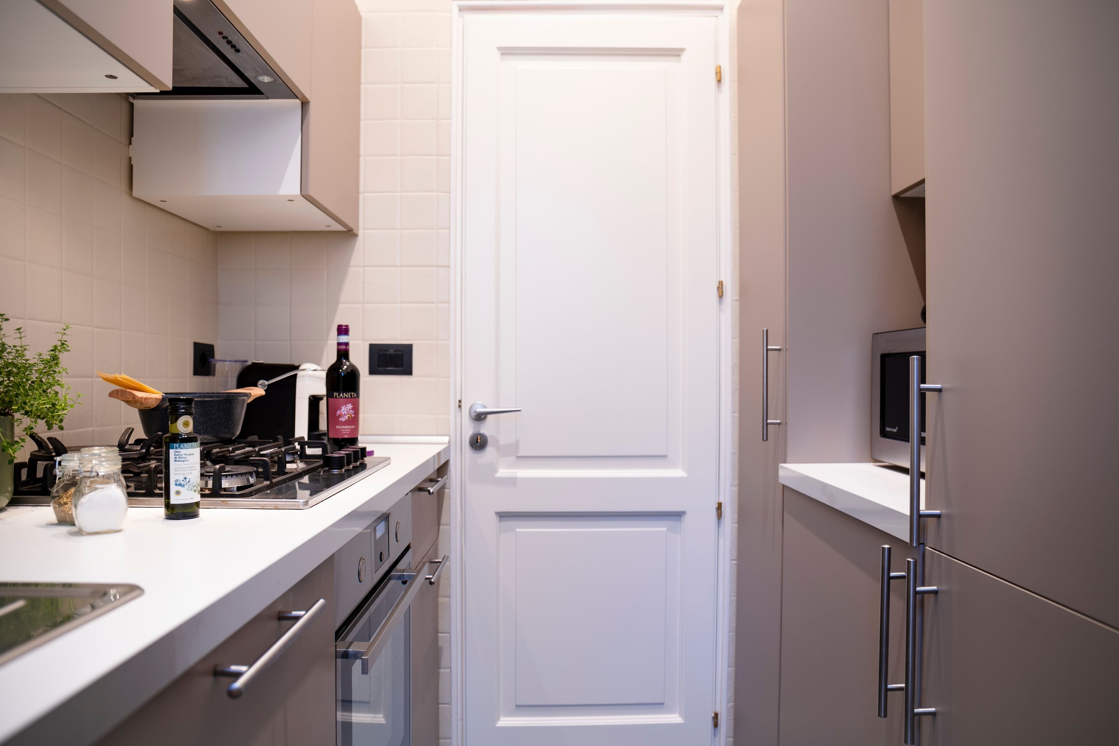 A modern kitchen with white cabinets, a stove, and a microwave.
