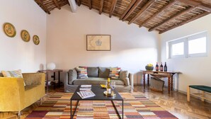 A cozy living room with a sofa, coffee table, and a patterned rug. - Planeta Palace - Apartment with terrace (Palermo)