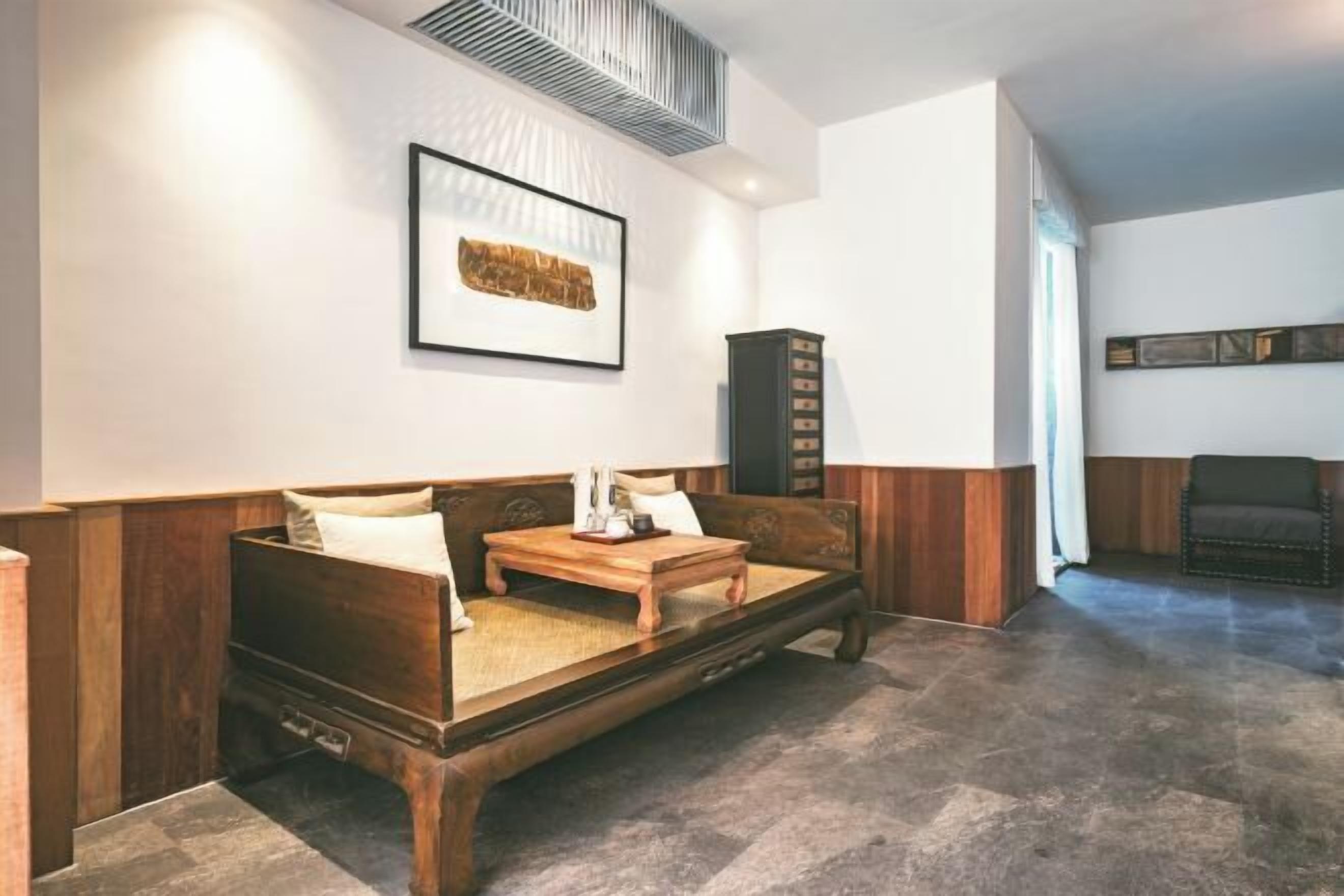 A cozy room with a wooden sofa, a small wooden table, and a cabinet.