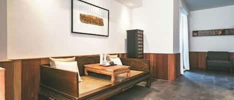 A cozy room with a wooden sofa, a small wooden table, and a cabinet.