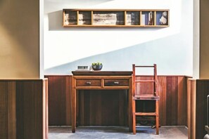 A corner room with a wooden desk, a chair, a shelf with books, and a potted plant. - Youjian Shibashe Inn (Suzhou)