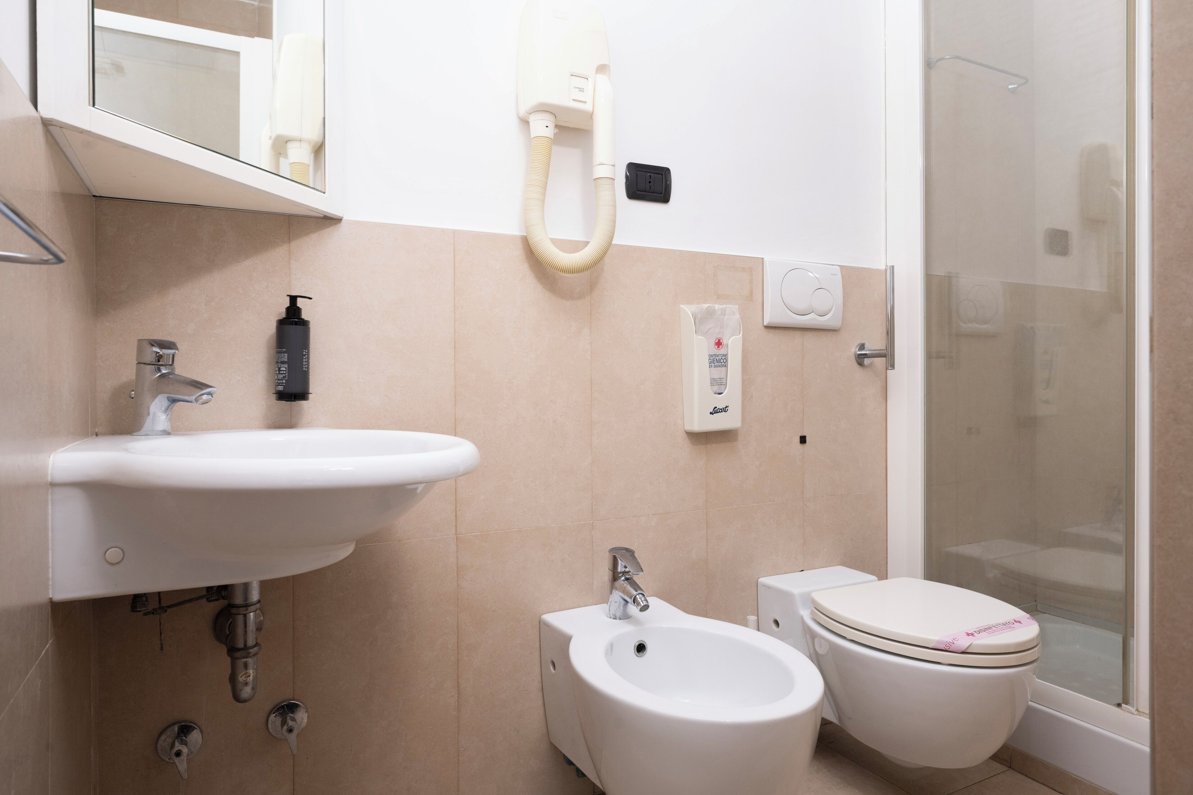 Une salle de bain moderne équipée d’un lavabo, d’un bidet, de toilettes et d’une douche à parois de verre.