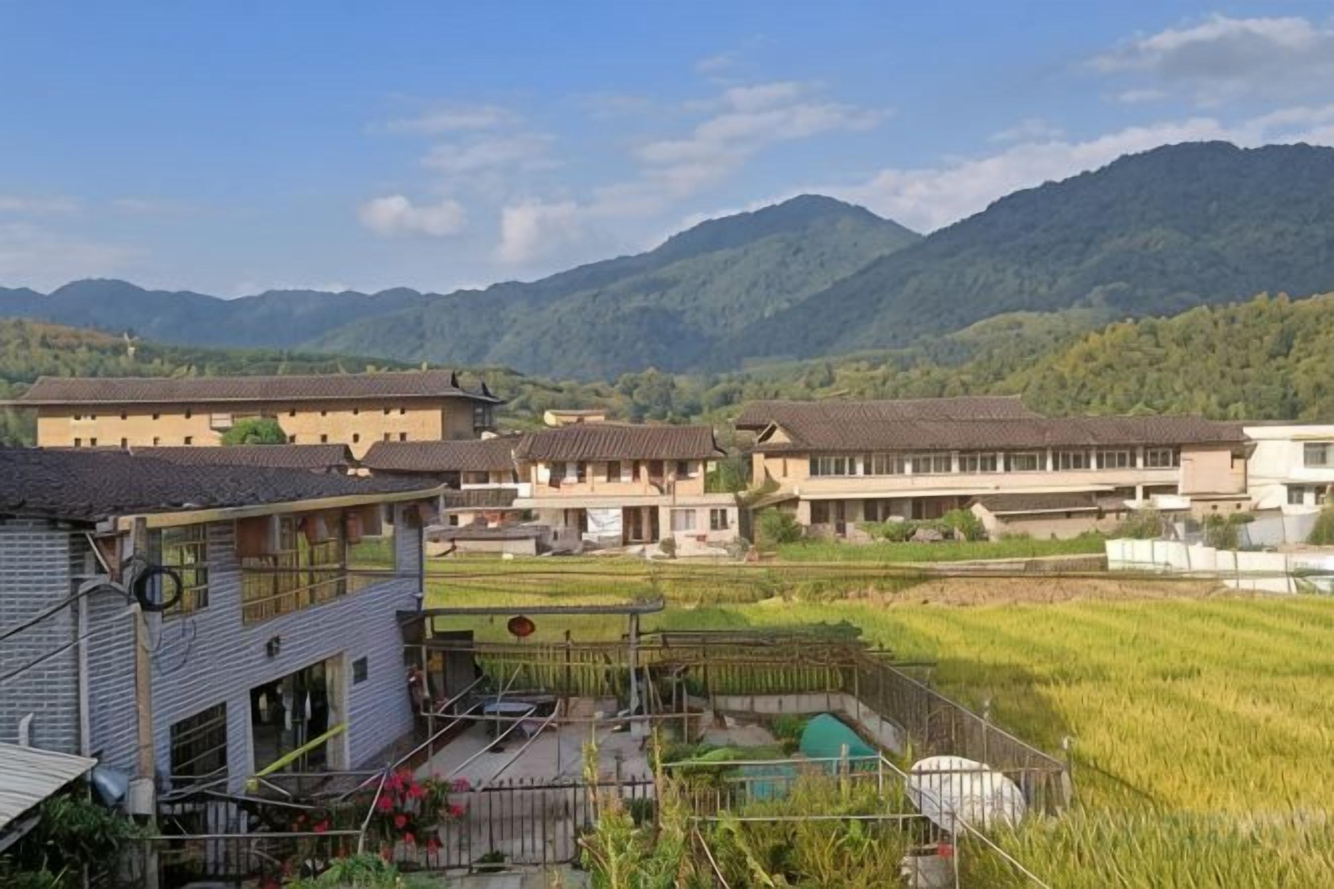Un barrio residencial con casas, una piscina y montañas al fondo.