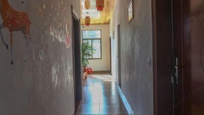 A hallway with a wooden ceiling, a large window, and a door on the right. - Yunshuiyao Yunshui Guest House (Nanjing County)