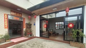 A building entrance with a brick facade, glass doors, and red lanterns. - Yunshuiyao Yunshui Guest House (Nanjing County)