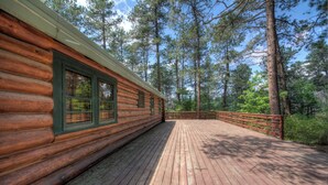 A log cabin with a wooden deck and a metal railing. - 1927 Cabin of Keystone (Keystone)