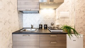 A modern kitchen with a marble backsplash, stainless steel appliances, and wooden cabinetry. - Cloud Swing Room 1 by Wonderful Italy (Bari)