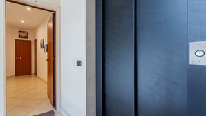 A modern interior with a dark-colored elevator, a wooden door, and a tiled floor. - Cloud Swing Room 1 by Wonderful Italy (Bari)