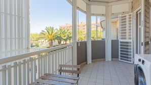 A balcony with a view of palm trees and buildings, a washing machine, and a bench. - Cloud Swing Room 1 by Wonderful Italy (Bari)
