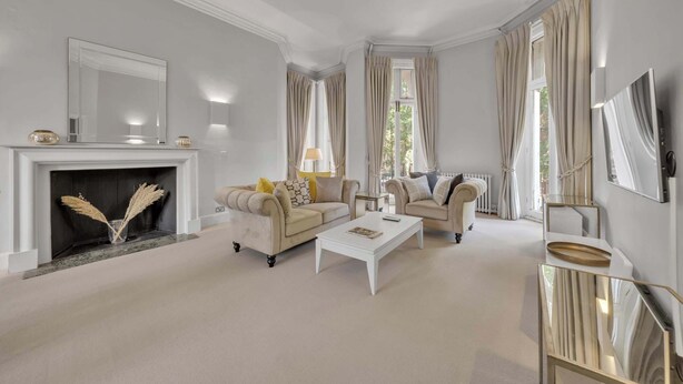 A living room with a fireplace, two sofas, a coffee table, and a TV. - Cosy One Bedroom Behind Harrods (Greater London)