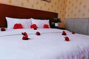 A hotel room with a large bed, white bedding, and red rose decorations. - Bayun Hotel (Wuyuan Bus Station) (Wuyuan)