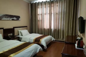 A hotel room with two beds, a flat-screen TV, a wooden nightstand, and a large window with curtains. - Bayun Hotel (Wuyuan Bus Station) (Wuyuan)