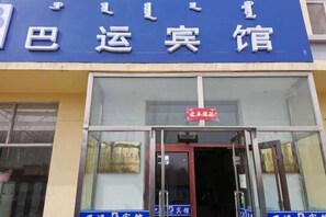 A hotel entrance with a blue sign above the door and a red sign indicating the hotel name. - Bayun Hotel (Wuyuan Bus Station) (Wuyuan)