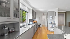 Una cocina moderna con una isla central, electrodomésticos integrados y vistas al exterior.
