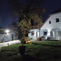 Um edifício moderno com telhado plano, escadaria aparente e gramado bem cuidado.