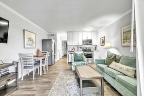Un salon moderne avec un canapé, une table basse et un coin repas.
