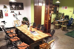 A conference room with a long table, multiple chairs, and a wooden floor.