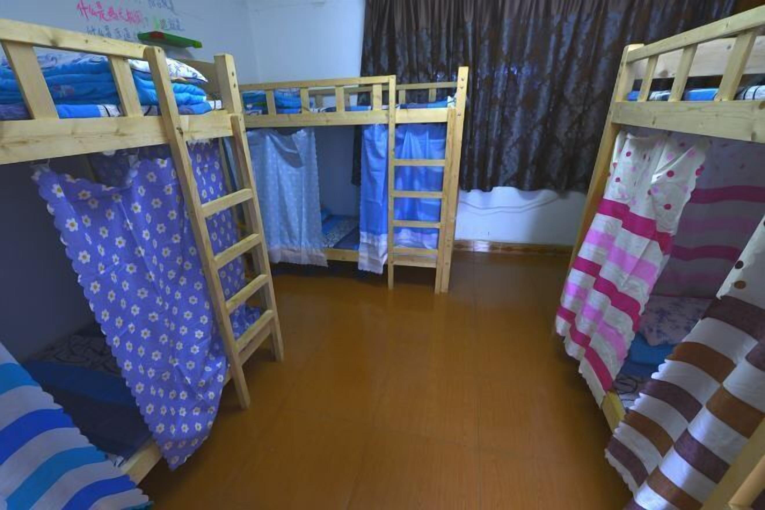 A room with bunk beds, a ladder, and a curtain.