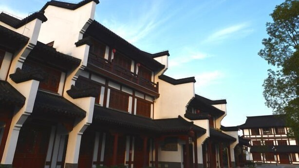 A traditional building with multiple levels and wooden balconies, featuring a classic architectural style. - Wuyishan Blue Sky Youth Hostel (Wuyishan)