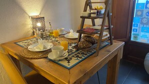 Een ontbijttafel met een dienblad, brood, een fles en een glas sinaasappelsap.