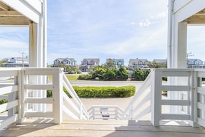 A wooden deck with a view of houses and a road.