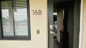 A door with the number 16B, a keypad lock, and a window with blinds. - Delva’s Place-Gated 3 bedroom - Pet Friendly (Freeport)