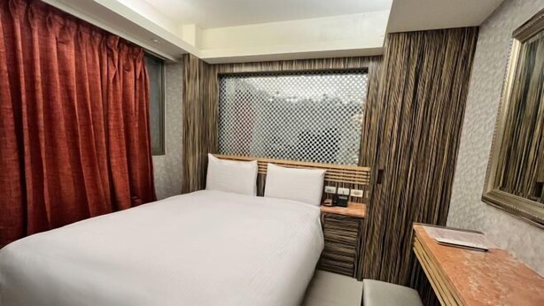 A hotel room with a bed, a desk, a chair, and a window with curtains. - Guide Hotel-Xinyi Branch（Ex HolyPro Hotel） (Taipei)