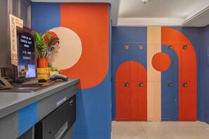A reception area with a counter, a plant, and a set of lockers. - Guide Hotel-Xinyi Branch(Ex HolyPro Hotel) (Taipei)