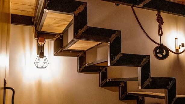 A staircase with geometric steps and a hanging light fixture.
