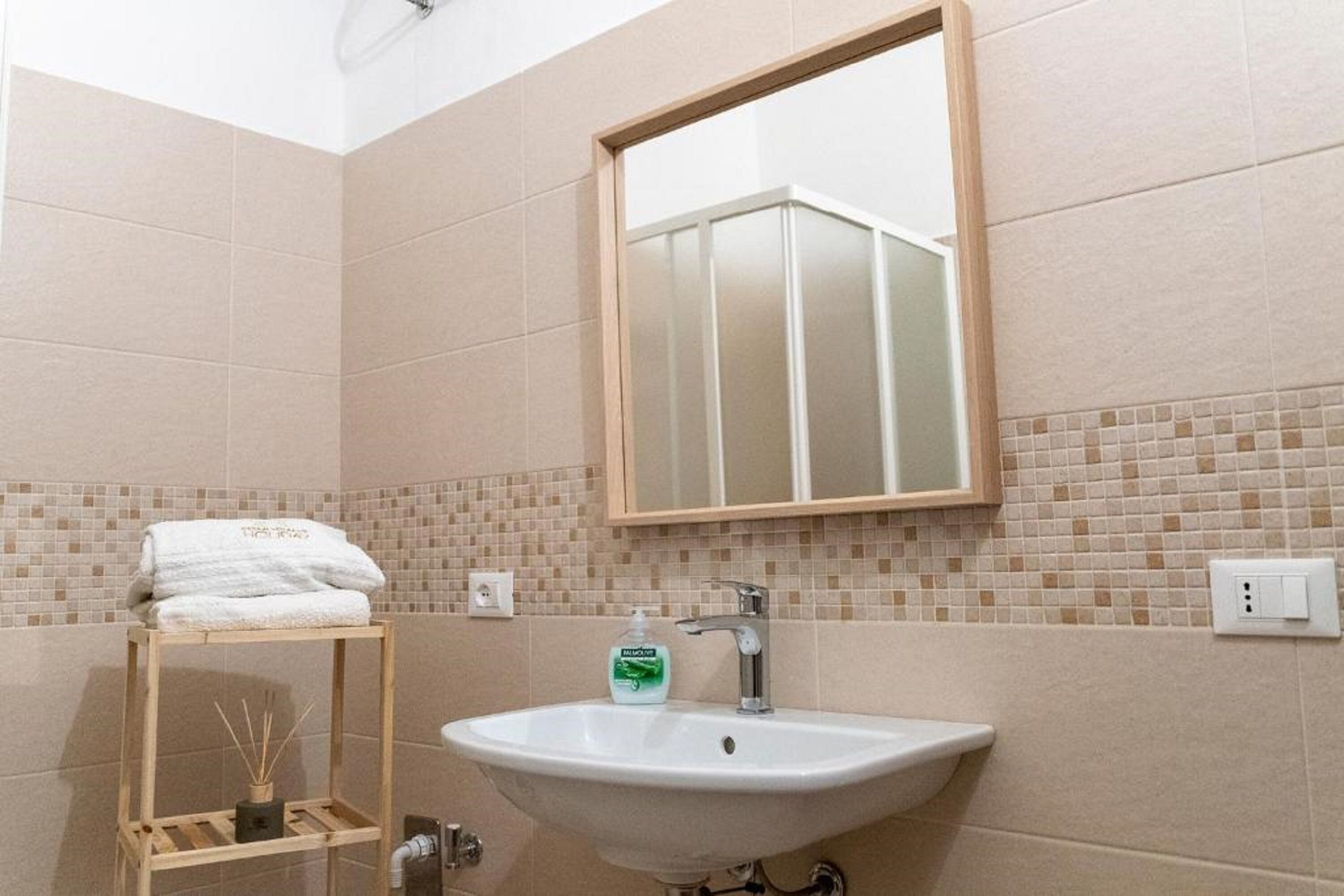 A bathroom with a white sink, a mirror, and a towel rack.
