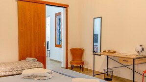 A bedroom with a bed, a desk, a chair, and a wardrobe.