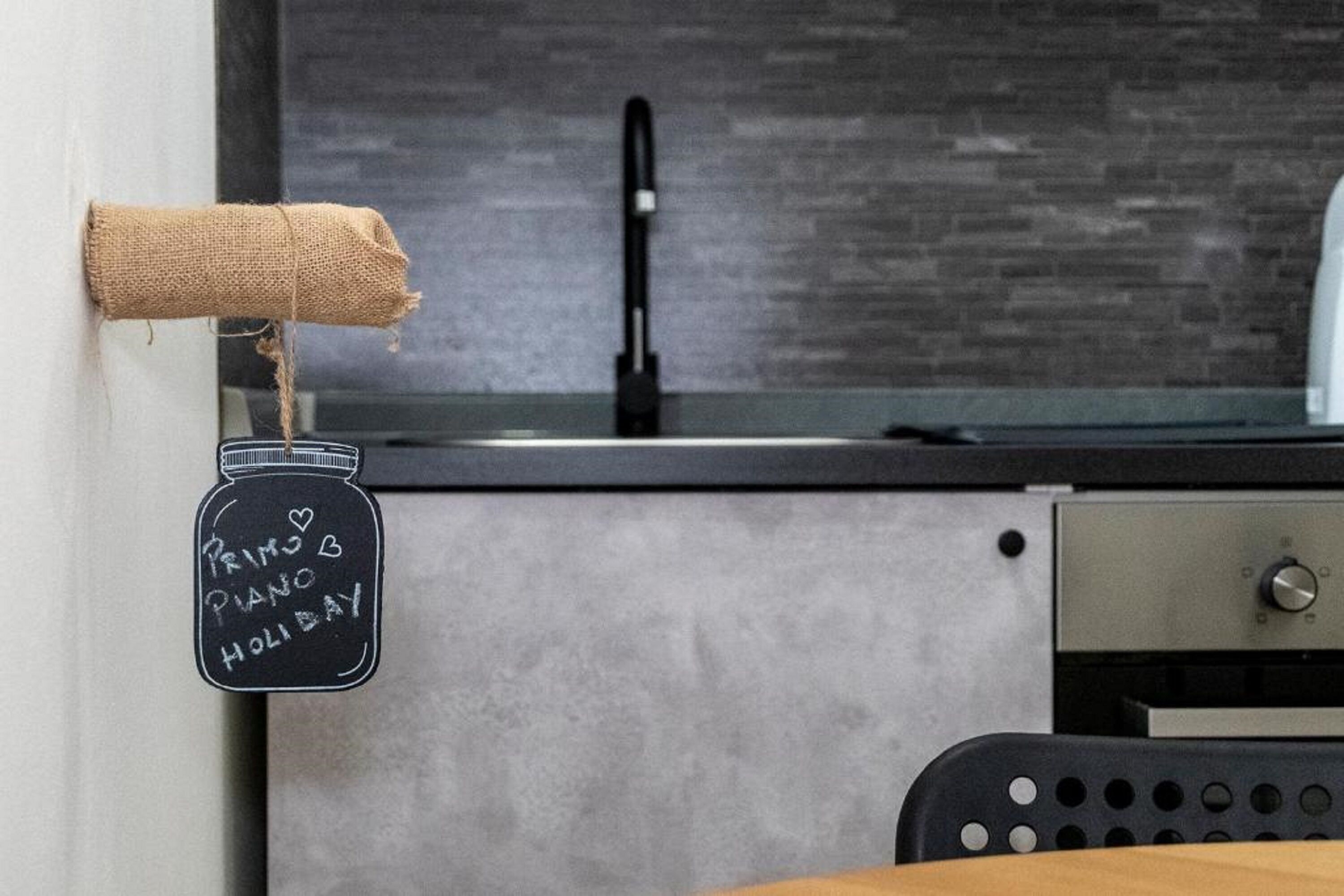 Une cuisine avec un plan de travail noir, un évier en acier inoxydable et une table en bois.